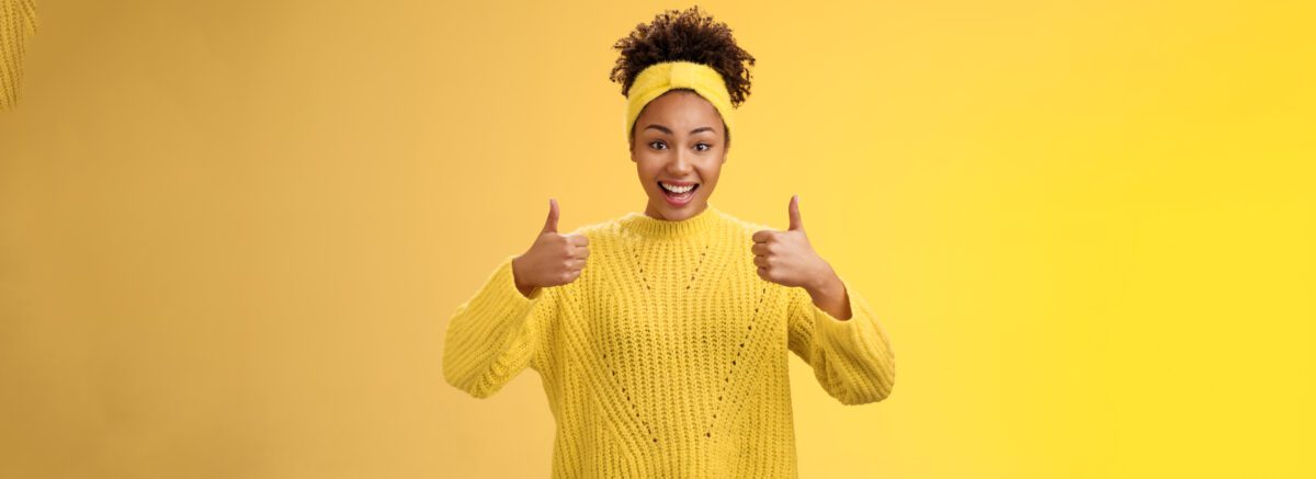 supportive friendly modern trendy african american female friend supporting you show thumbs up keep up good work gesture proud doing best effort, liking result approving plan, yellow background